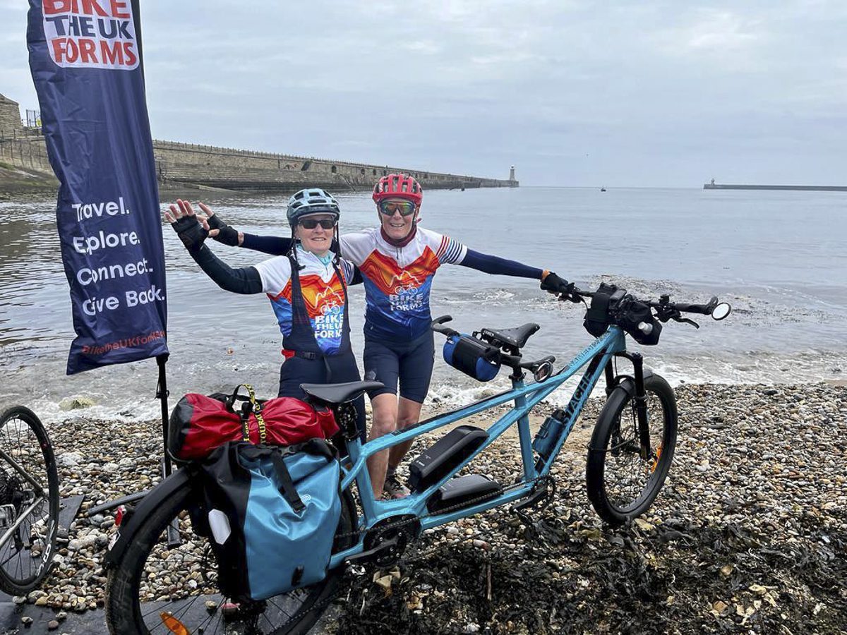 Teresa Attwood and Linda Bussey with their tandem E-Bike helping them ride with MS. Celebrating at the Sea to Sea finish line.