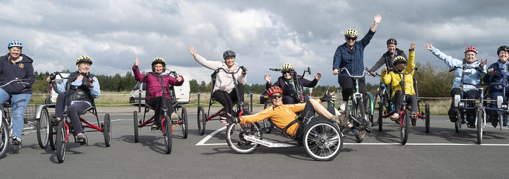 11 members of East Cumbria MS group riding their adapted bikes at Watchtree Cycle Hire