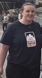 Woman stood smiling at the camera in a bike the UK for MS t-shirt